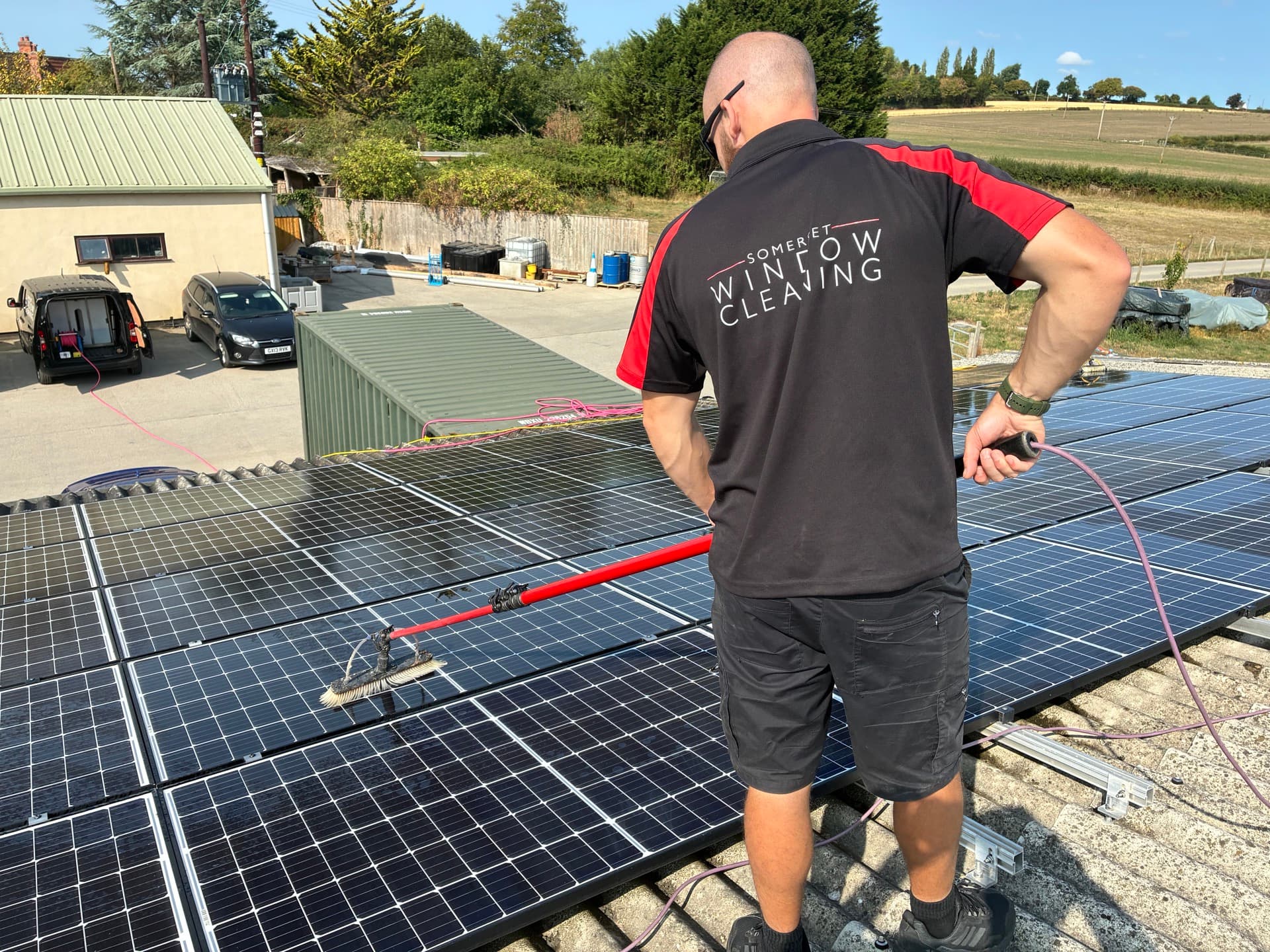 Technician cleaning roof-mounted solar panels