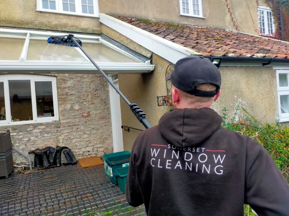 Somerset Window Cleaning technician cleaning a conservatory roof with a pole brush