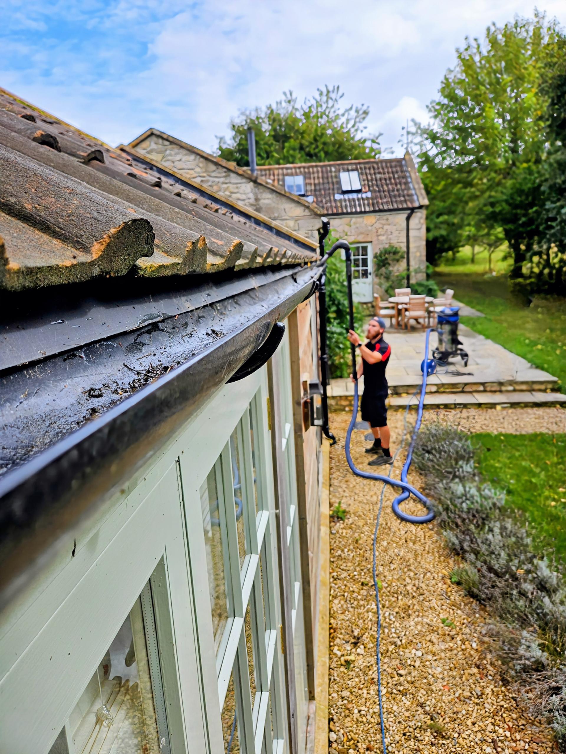 Technician using high reach gutter vacuum