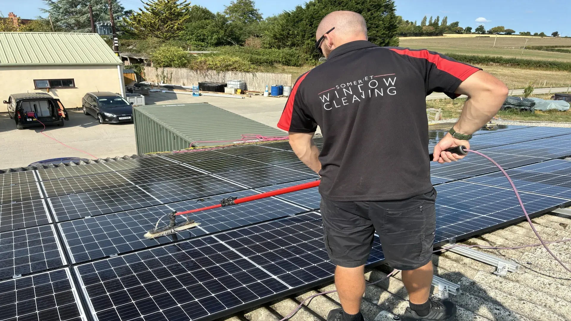 Technician cleaning roof-mounted solar panels