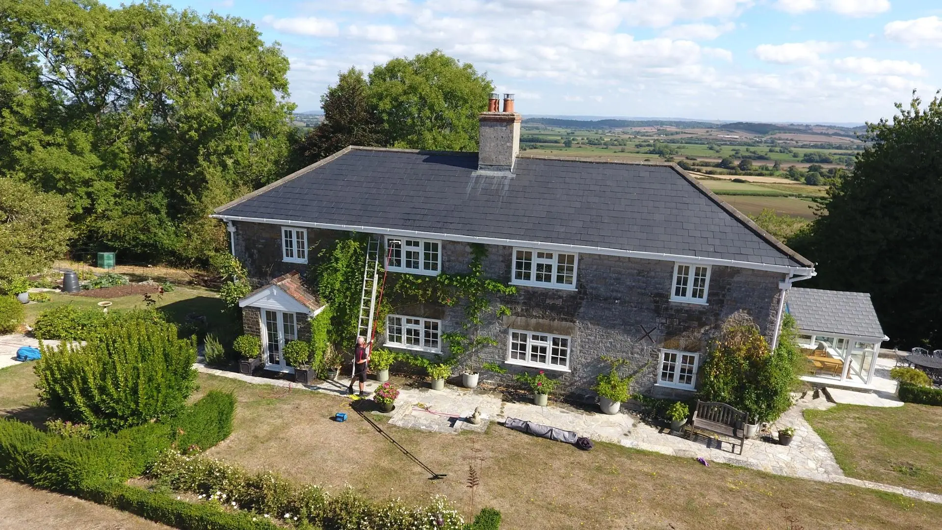 Technician soft washing rendered exterior wall