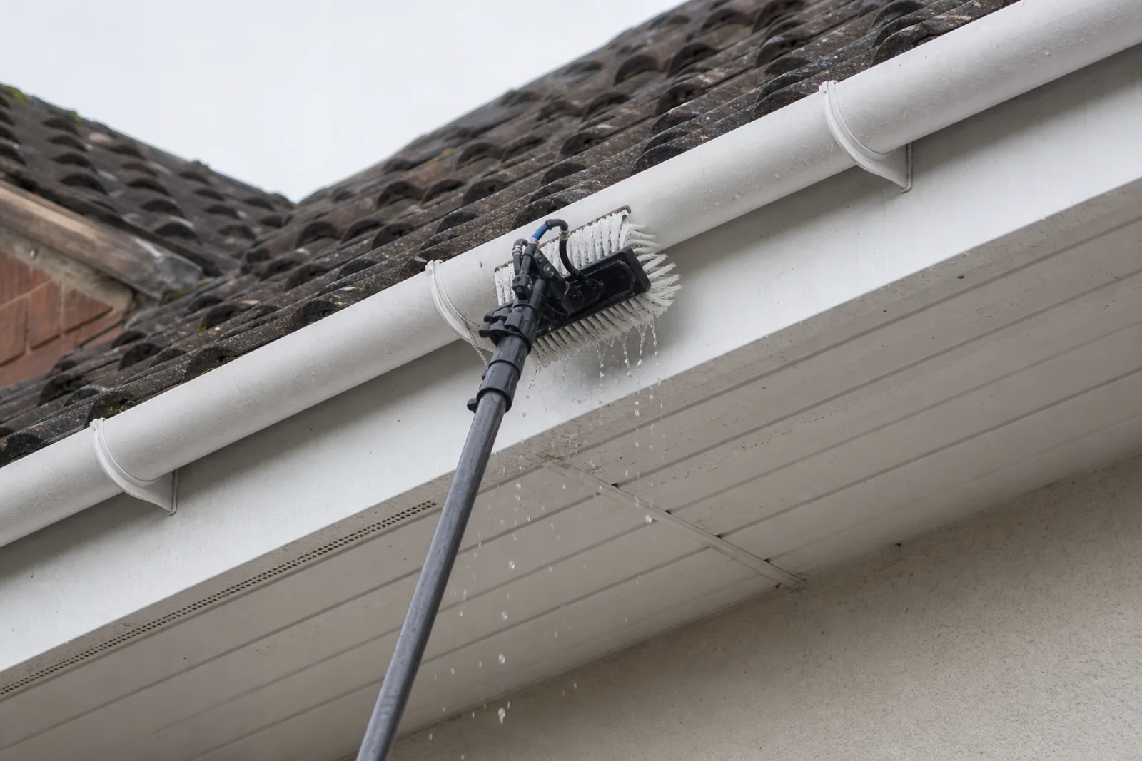 Fascias and soffits being cleaned with a telescopic pole on a Somerset home