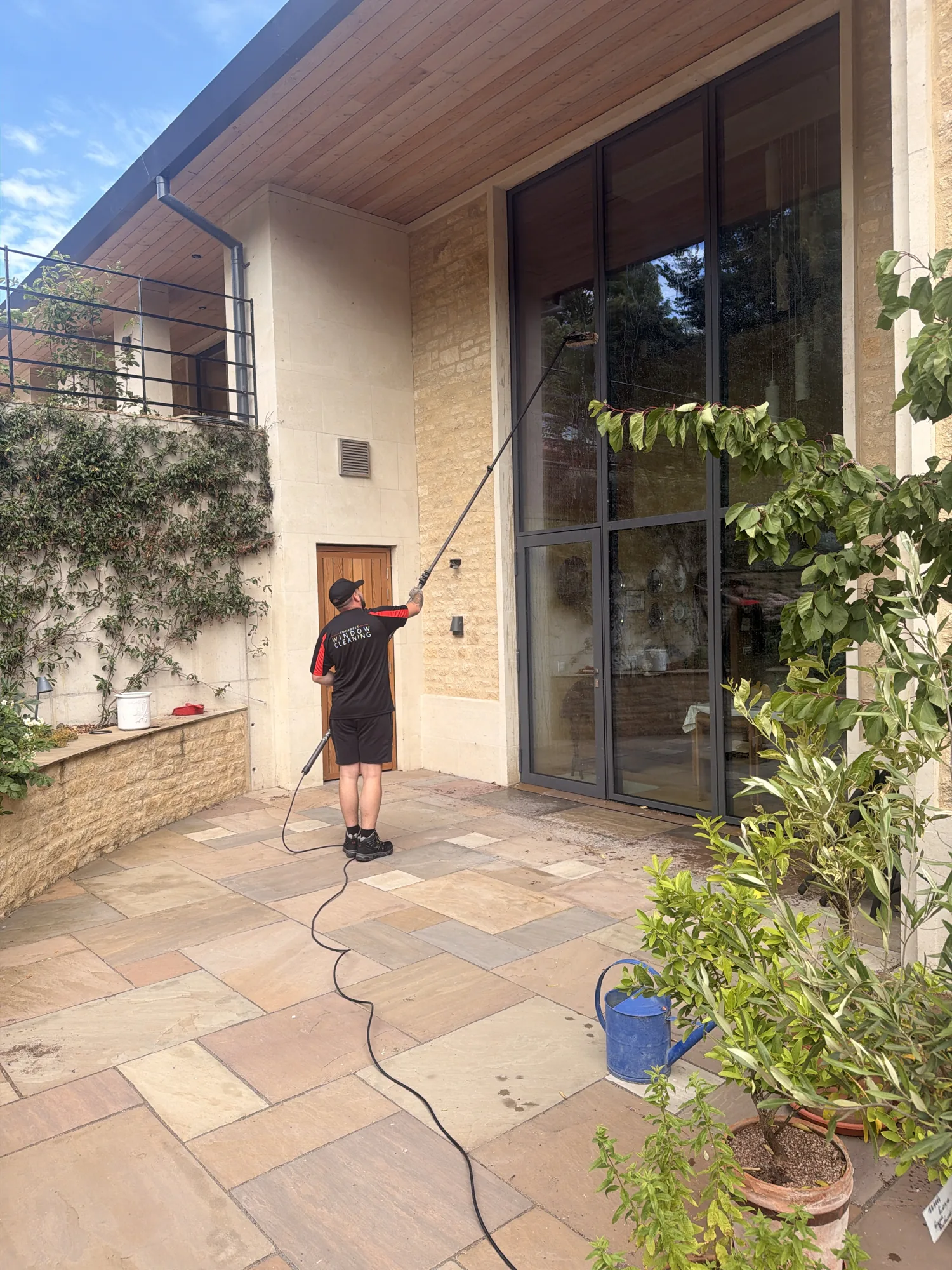 Somerset Window Cleaning technician cleaning double-height windows with a reach-and-wash pole