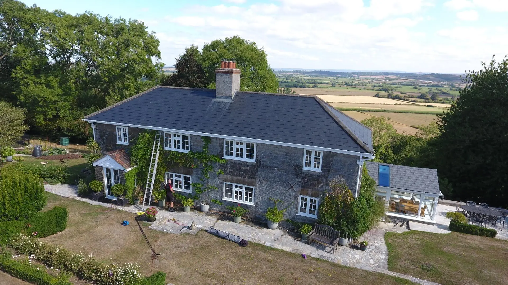 A Somerset stone farmhouse with beautifully clean windows in soft countryside light