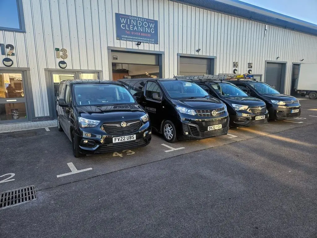 The branded black Somerset Window Cleaning fleet outside the unit